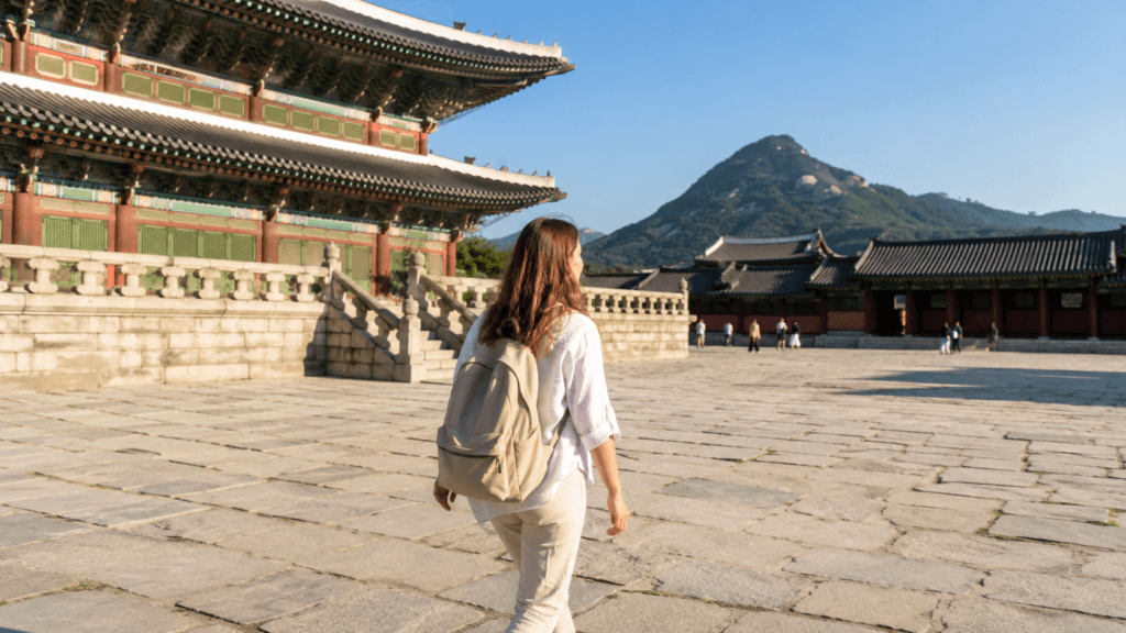 International traveler walking through the courtyard of Gyeongbokgung Palace in Seoul