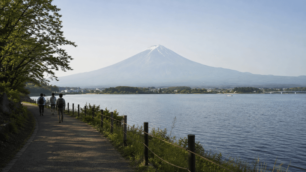 Travelers walking beside Lake Kawaguchiko with Mount Fuji in the background
