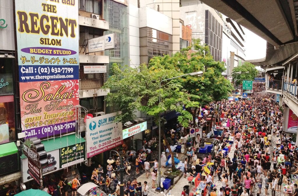 Dense Songkran crowds on Silom Road beneath Bangkok's elevated rail line in April 2013