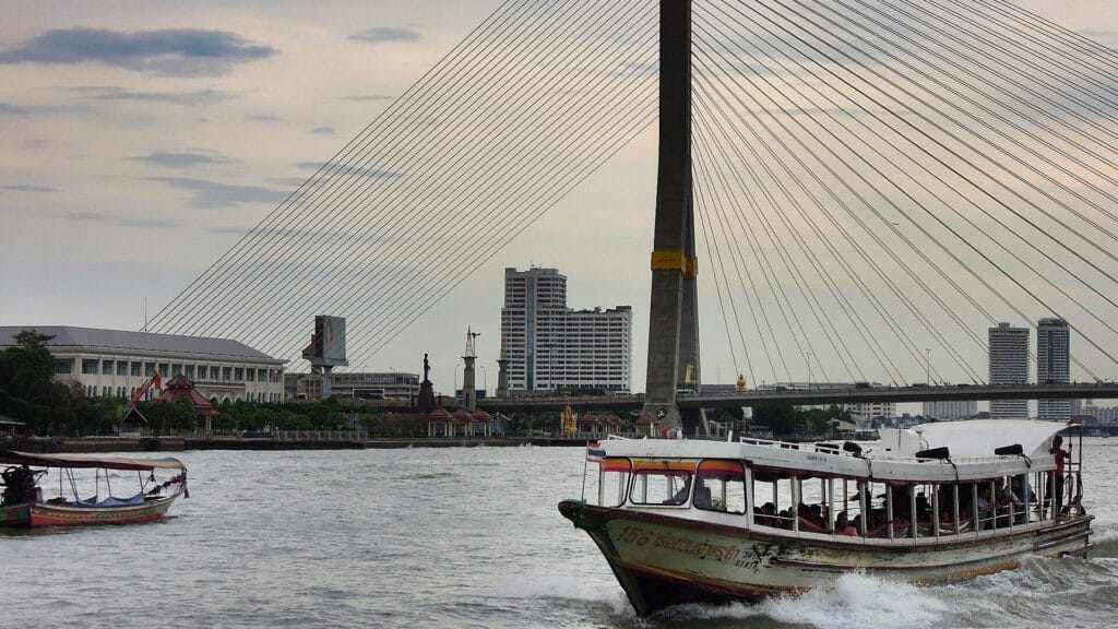 A Chao Phraya express boat passing beneath Bangkok's Rama VIII Bridge