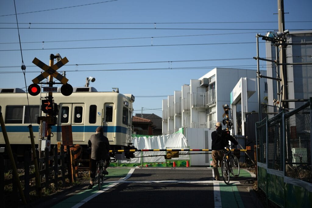 Pedestrians and cyclists crossing the railway in Tokyo's Shimokitazawa neighborhood
